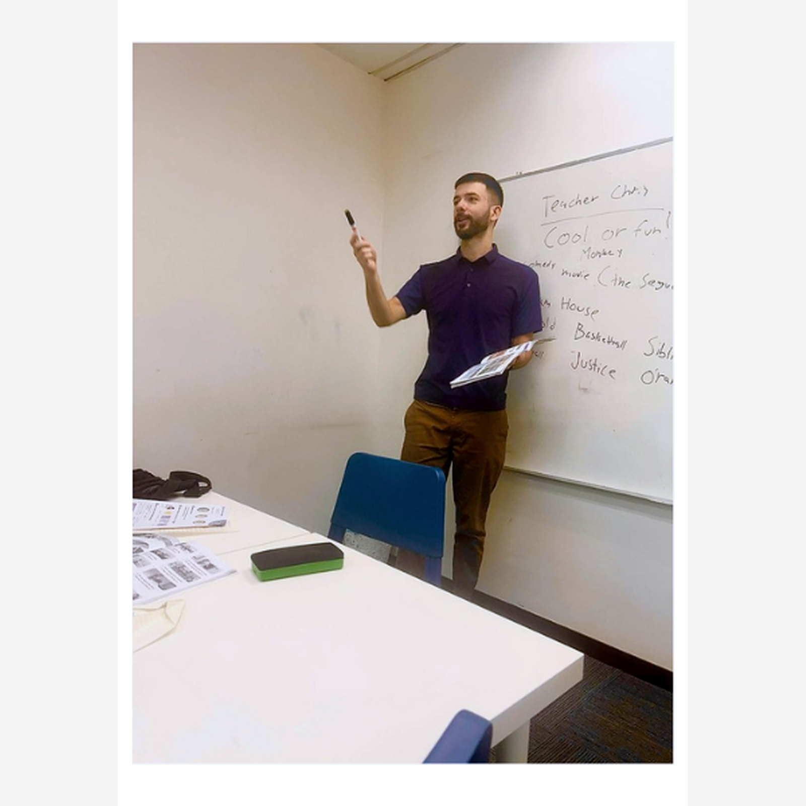 Teacher Chris teaching an English speaking lesson at a whiteboard