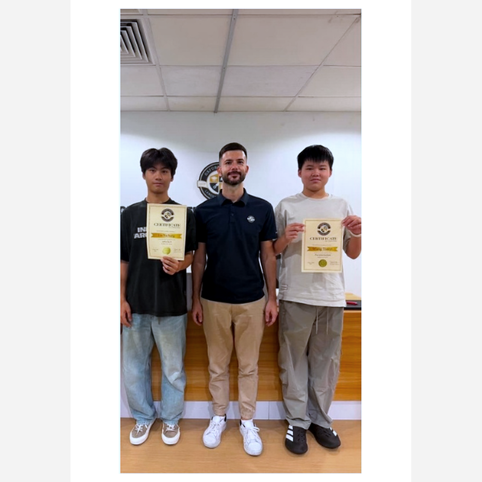 Teacher Chris presenting English-course certificates to students